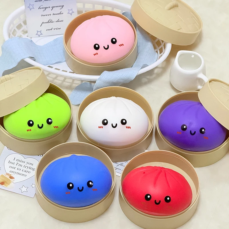 Plusieurs squishys bao colorés alignés dans leurs paniers vapeur en bambou.