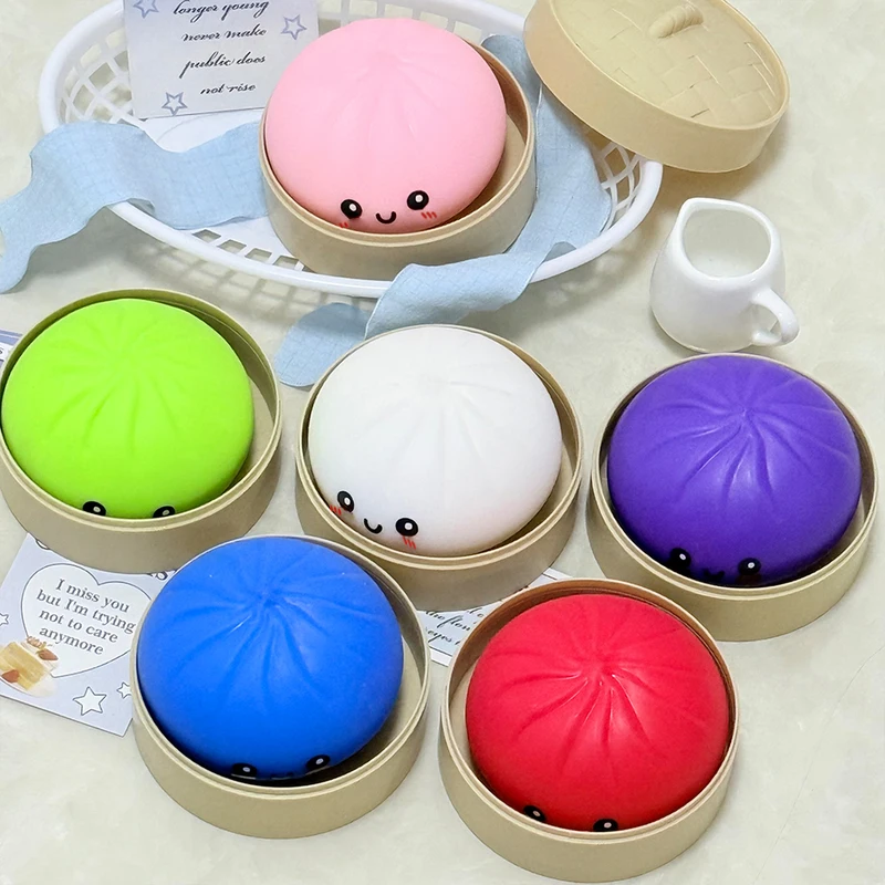 Squishys bao de différentes couleurs posés côte à côte sur une surface claire.